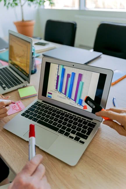 A diverse team collaborating on digital marketing strategies at a desk, using laptops and tablets.