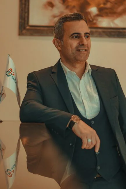 Two businessmen analyze stock market data using a smartphone and laptop in a modern office setting.